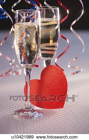 Flutes with champagne and red paper heart, close-up View Large Photo Image Stock Photo - Flutes with champagne and red paper heart, close-up. Fotosearch