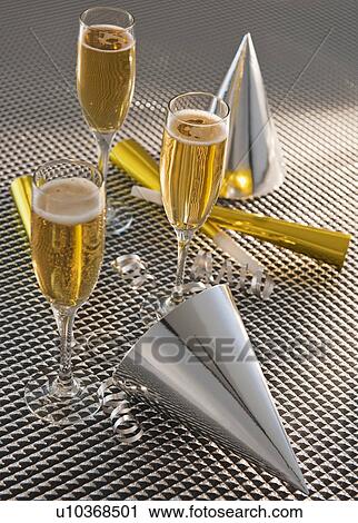 Flutes with champagne, party horn blowers and paper party hats View Large Photo Image Stock Image - Flutes with champagne, party horn blowers and paper party hats. Fotosearch