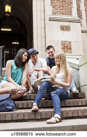 Stock Photography - Four college students sitting on steps. Fotosearch