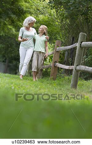 Girl (10-11) and grandmother walking together View Large Photo Image Stock Image - Girl (10-11) and grandmother walking together. Fotosearch