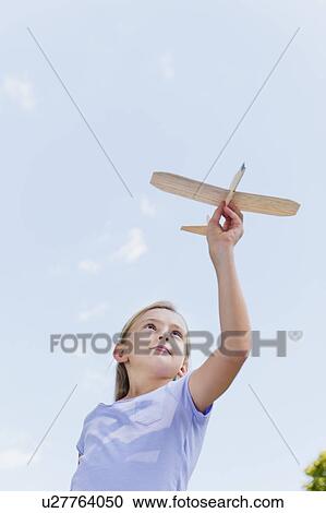 Girl (10-11) playing with toy plane View Large Photo Image Stock Image - Girl (10-11) playing with toy plane. Fotosearch