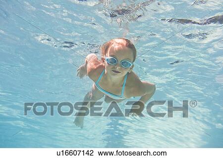 Stock Image - Girl (10-11) swimming underwater. Fotosearch