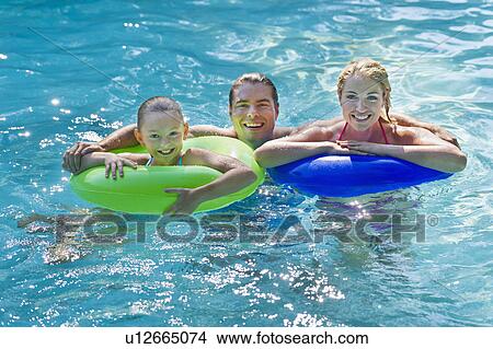 Girl (10-11) with parents in swimming pool View Large Photo Image Picture - Girl (10-11) with parents in swimming pool. Fotosearch