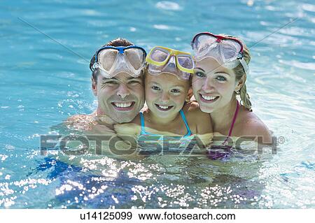 Stock Photo - Girl (10-11) with parents in swimming pool. Fotosearch