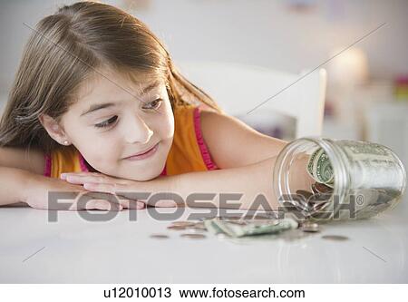 Girl ( 6-7) looking at savings in jar View Large Photo Image Stock Image - Girl ( 6-7) looking at savings in jar. Fotosearch