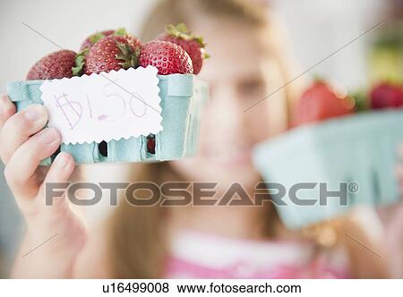 Stock Photo - Girl ( 6-7) selling fresh strawberries. Fotosearch