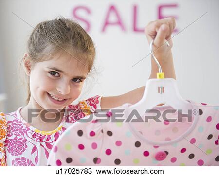 Girl ( 6-7) showing clothes while shopping View Large Photo Image Stock Image - Girl ( 6-7) showing clothes while shopping. Fotosearch