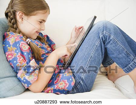 Stock Image - Girl ( 6-7) using digital tablet. Fotosearch