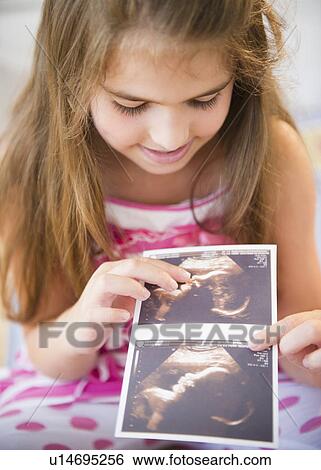 Girl ( 6-7) watching sonogram picture View Large Photo Image Stock Photograph - Girl ( 6-7) watching sonogram picture. Fotosearch
