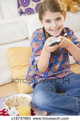 Stock Image - Girl ( 6-7) watching tv. Fotosearch