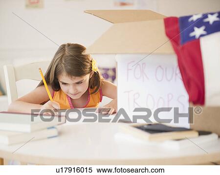 Stock Photography - Girl ( 6-7) working at desk for charity. Fotosearch
