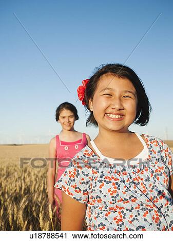 Girls (10-11, 12-13) standing in whet field View Large Photo Image Stock Image - Girls (10-11, 12-13) standing in whet field. Fotosearch