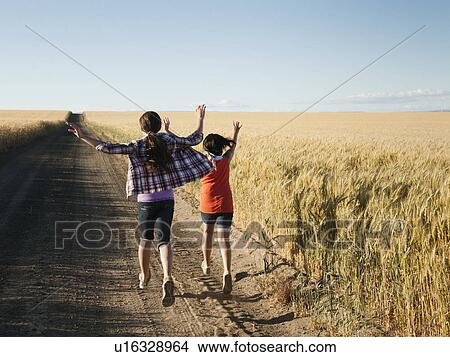 Girls (12-13, 10-11) running along dirt road View Large Photo Image Picture - Girls (12-13, 10-11) running along dirt road. Fotosearch