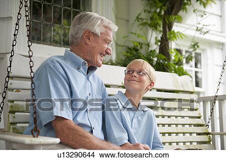 Grandfather and grandson (10-11) sitting on porch swing View Large Photo Image Picture - Grandfather and grandson (10-11) sitting on porch swing. Fotosearch