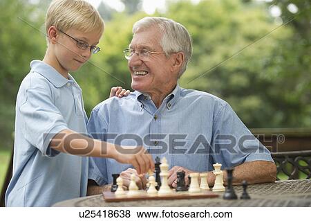 Grandfather and grandson (10-11) playing chess on porch View Large Photo Image Stock Photo - Grandfather and grandson (10-11) playing chess on porch. Fotosearch