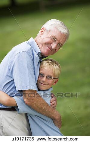 Stock Photograph - Grandfather and grandson (10-11) embracing. Fotosearch