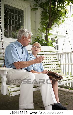 Grandfather and grandson (10-11) sitting on porch swing View Large Photo Image Stock Photography - Grandfather and grandson (10-11) sitting on porch swing. Fotosearch