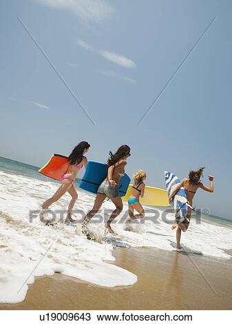 Group of young attractive women running into water with surfboards View Large Photo Image Stock Image - Group of young attractive women running into water with surfboards. Fotosearch