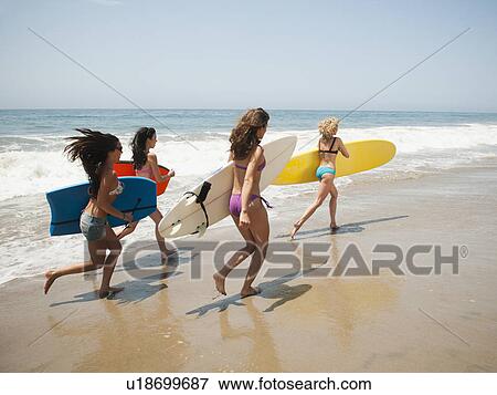 Group of young attractive women running into water with surfboards View Large Photo Image Stock Photo - Group of young attractive women running into water with surfboards. Fotosearch