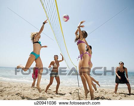 Group of young women playing beach volleyball View Large Photo Image Stock Photograph - Group of young women playing beach volleyball . Fotosearch