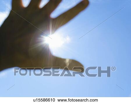 Stock Image - Hand in front of sun. Fotosearch