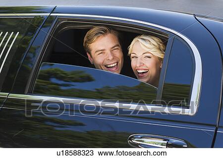 Stock Image - Happy married couple in limousine. Fotosearch