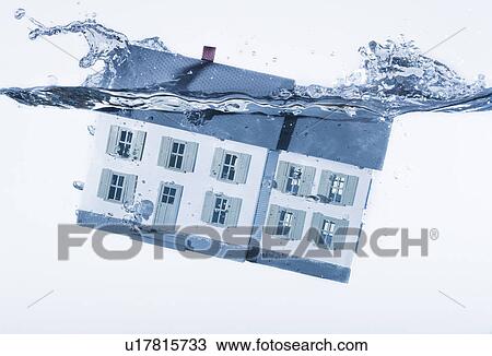 Stock Image - House model splashing into water, studio shot. Fotosearch