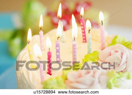 Picture - Illuminated candles on cake. Fotosearch
