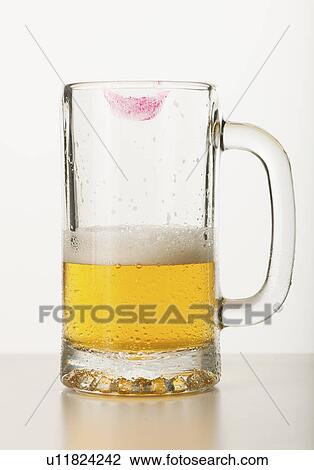 Stock Image - Lipstick on beer glass, studio shot. Fotosearch
