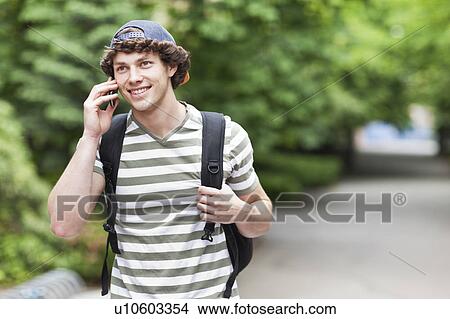 Male college student talking on cell phone View Large Photo Image Picture - Male college student talking on cell phone. Fotosearch
