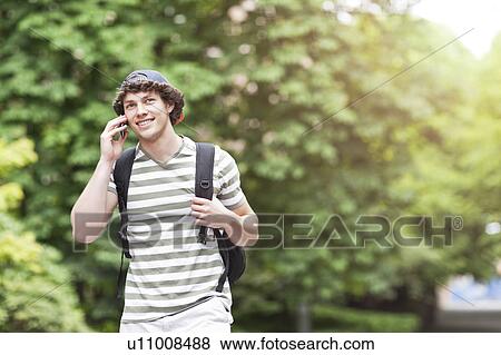 Male college student talking on cell phone View Large Photo Image Stock Photo - Male college student talking on cell phone. Fotosearch
