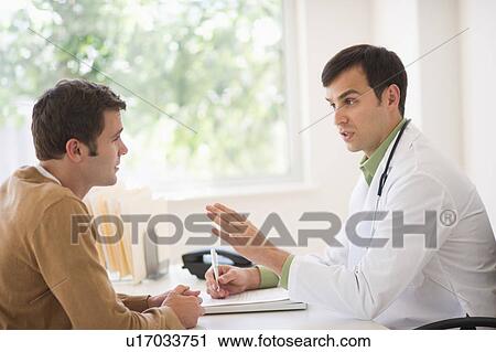Stock Image - Man receiving advice from doctor in office. Fotosearch