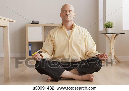 Mature businessman meditating in office View Large Photo Image Stock Image - Mature businessman meditating in office. Fotosearch