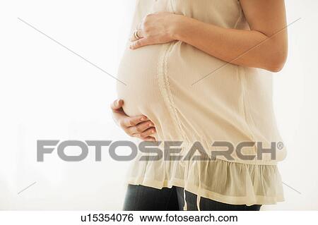 Midsection of pregnant woman with hands on stomach View Large Photo Image Stock Photograph - Midsection of pregnant woman with hands on stomach. Fotosearch