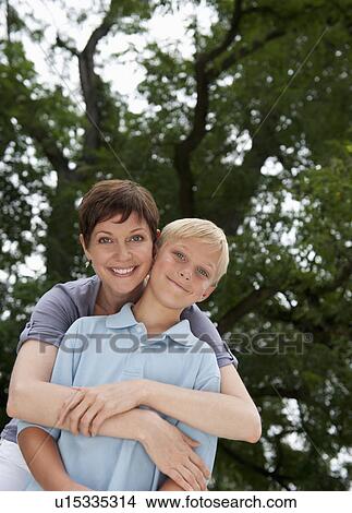 Mother embracing son (10-11) View Large Photo Image Picture - Mother embracing son (10-11). Fotosearch