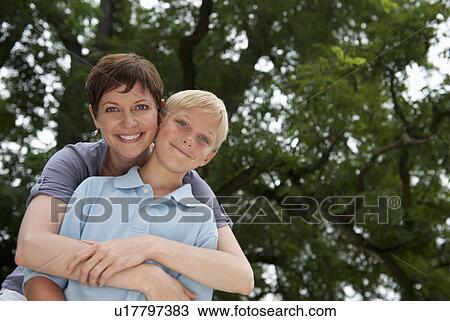 Stock Image - Mother embracing son (10-11). Fotosearch