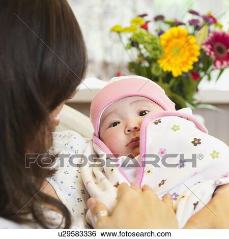 Stock Photograph - Mother holding baby daughter (2-5 months). Fotosearch