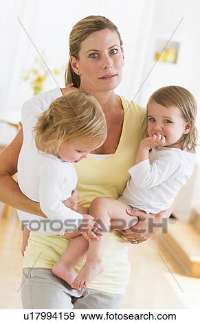 Mother holding daughters (2-3) and making facial expression View Large Photo Image Stock Photo - Mother holding daughters (2-3) and making facial expression. Fotosearch