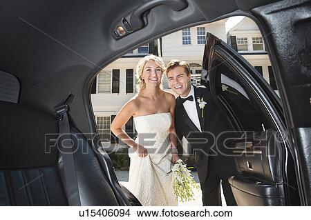 Picture - Newly wed couple near limousine. Fotosearch