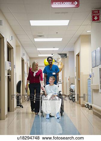 Nurse and mother walking behind boy's (10-11) wheelchair View Large Photo Image Stock Photo - Nurse and mother walking behind boy's (10-11) wheelchair. Fotosearch