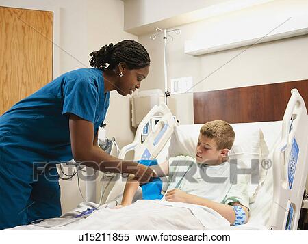 Stock Photography - Nurse checking blood pressure to boy (10-11). Fotosearch