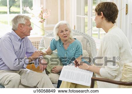 Stock Photo - Nursing assistant talking with seniors in Nursing home. Fotosearch