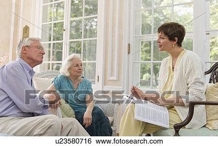 Stock Photograph - Nursing assistant talking with seniors in Nursing home. Fotosearch