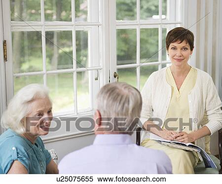 Stock Photography - Nursing assistant talking with seniors in Nursing home. Fotosearch