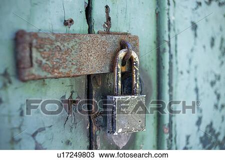 Stock Image - Old rusty padlock on door. Fotosearch