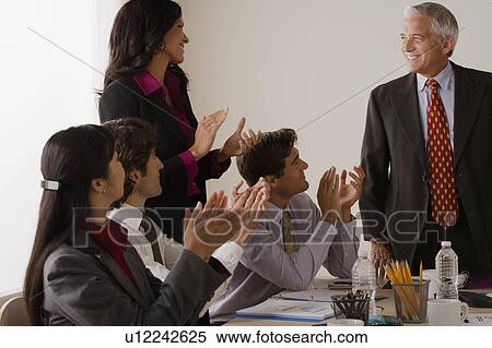 Stock Photography - People at business meeting clapping. Fotosearch