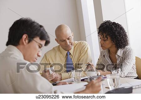 Stock Photograph - People discussing at business meeting. Fotosearch