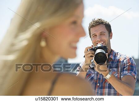 Stock Image - Photographer taking picture of woman. Fotosearch