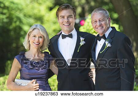 Stock Image - Portrait bridegroom with parents at wedding. Fotosearch