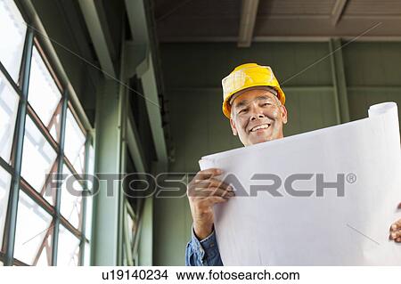 Portrait of architect holding blueprint View Large Photo Image Picture - Portrait of architect holding blueprint. Fotosearch